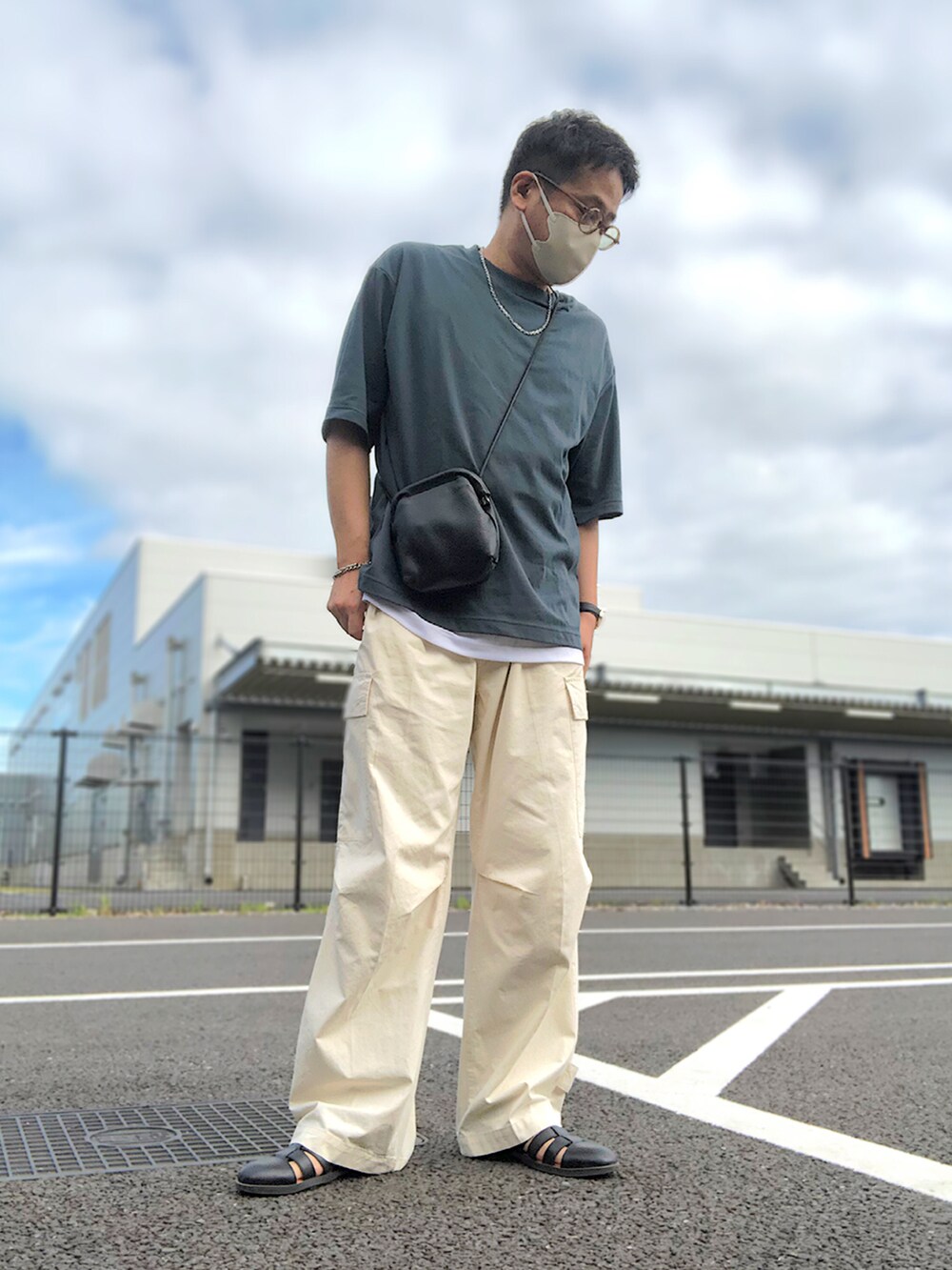 ベージュ系のセットアップ、グリーン系のTシャツ/カットソー、ブラック系のショルダーバッグを着用したメンズの夏コーディネートの2枚目の写真