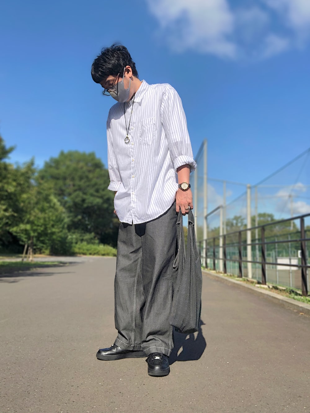 グレー系のベスト、ホワイト系のシャツ/ブラウス、グレー系のトートバッグを着用したメンズの秋コーディネートの2枚目の写真
