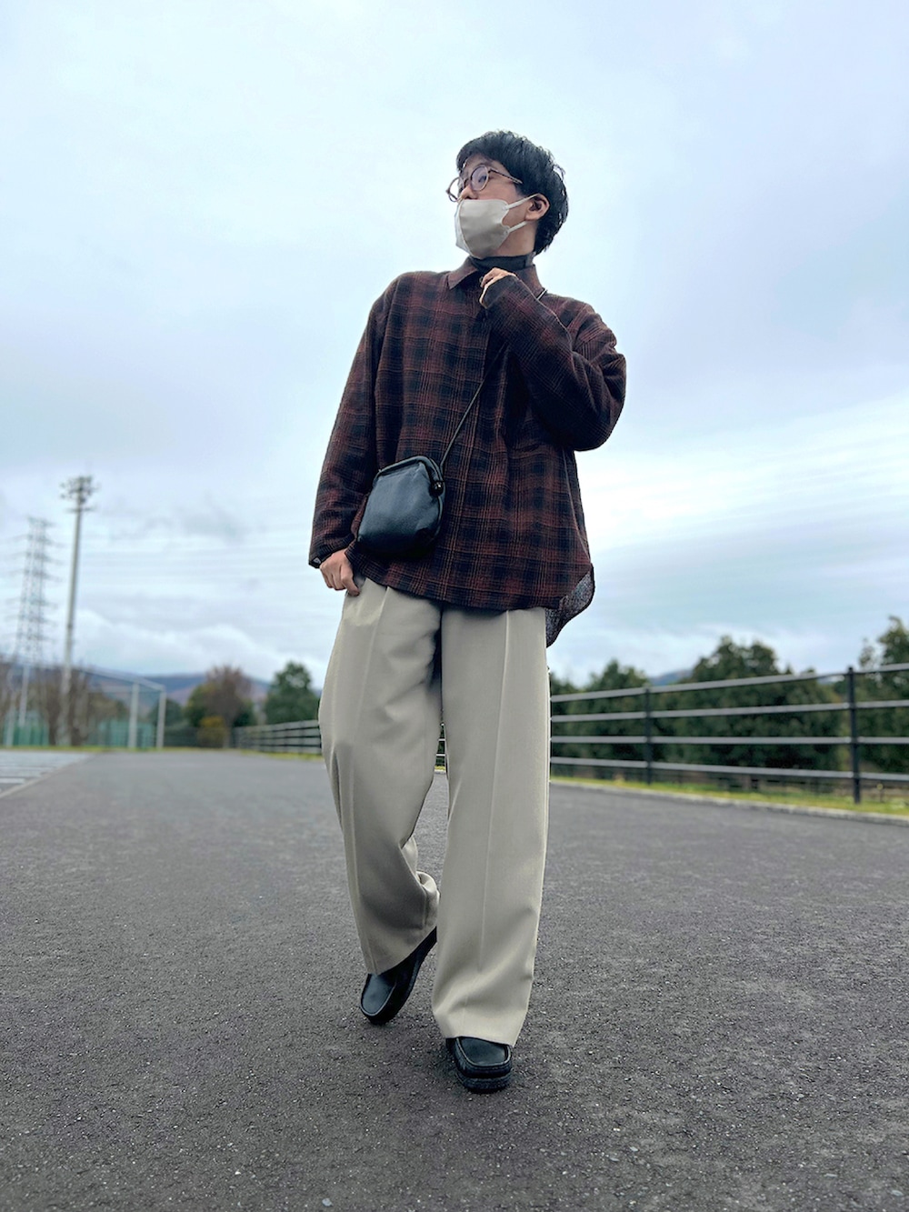 オレンジ系のシャツ/ブラウス、ブラウン系のステンカラーコート、ブラック系のショルダーバッグを着用したメンズの冬コーディネートの3枚目の写真