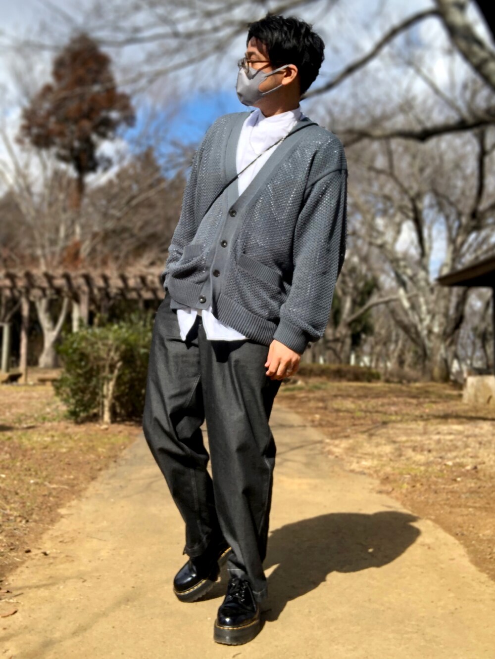 グリーン系のカーディガン/ボレロ、グレー系のトレンチコート、ブラック系のドレスシューズを着用したメンズの冬コーディネートの2枚目の写真