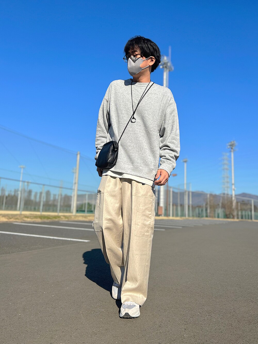 グレー系のブルゾン、グレー系のスウェット、ブラック系のショルダーバッグを着用したメンズの春コーディネートの3枚目の写真