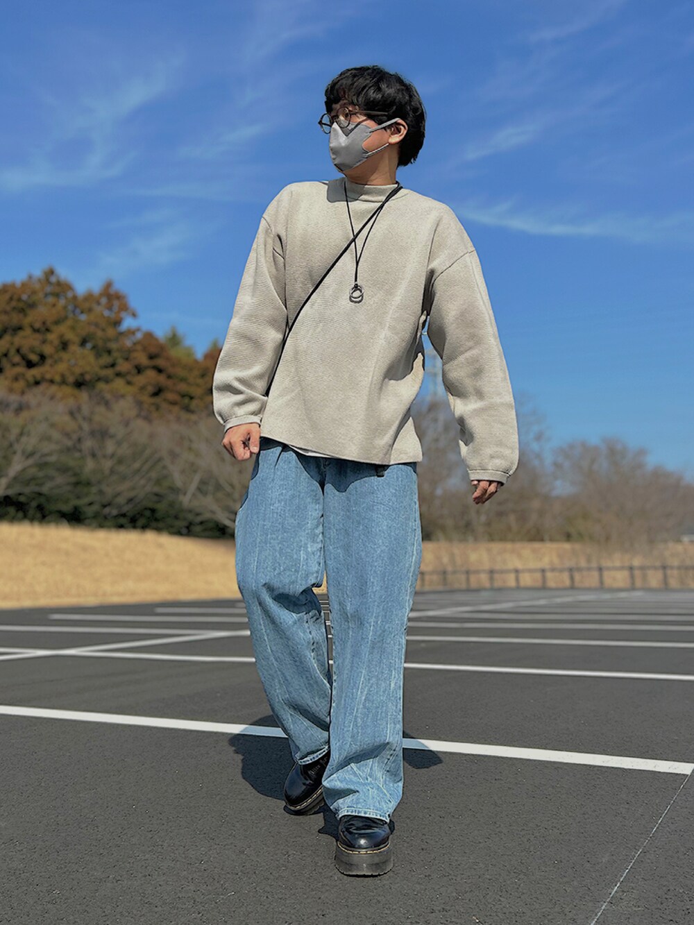 グレー系のブルゾン、グレー系のニット/セーター、ブラック系のショルダーバッグを着用したメンズの春コーディネートの3枚目の写真