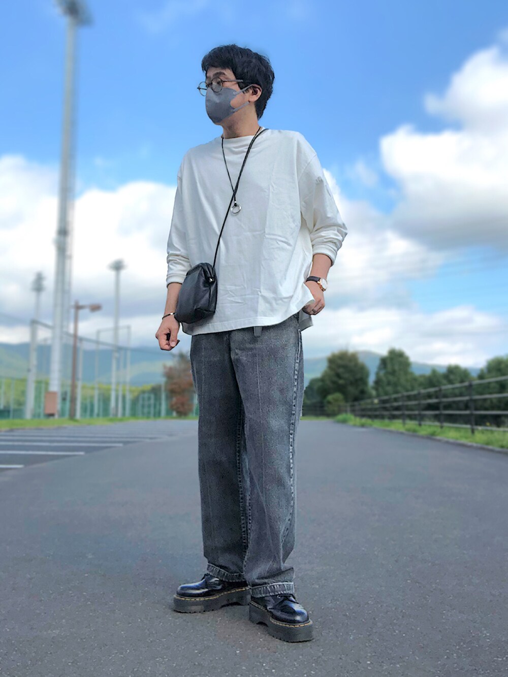 グレー系のベスト、ホワイト系のTシャツ/カットソー、ブラック系のショルダーバッグを着用したメンズの秋コーディネートの2枚目の写真