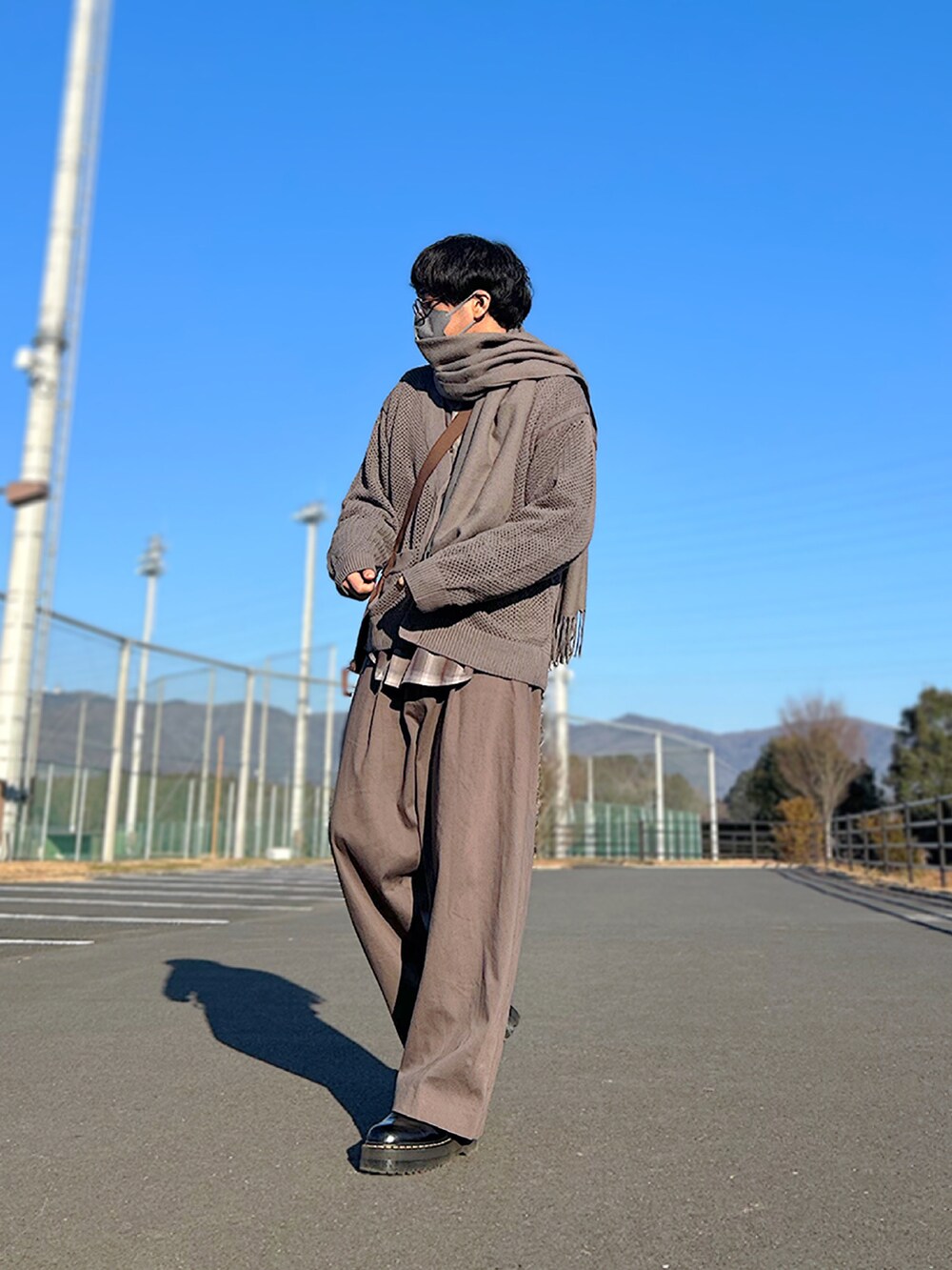 ブラック系のモッズコート、ブラウン系のカーディガン/ボレロ、ブラウン系のシャツ/ブラウスを着用したメンズの冬コーディネートの2枚目の写真