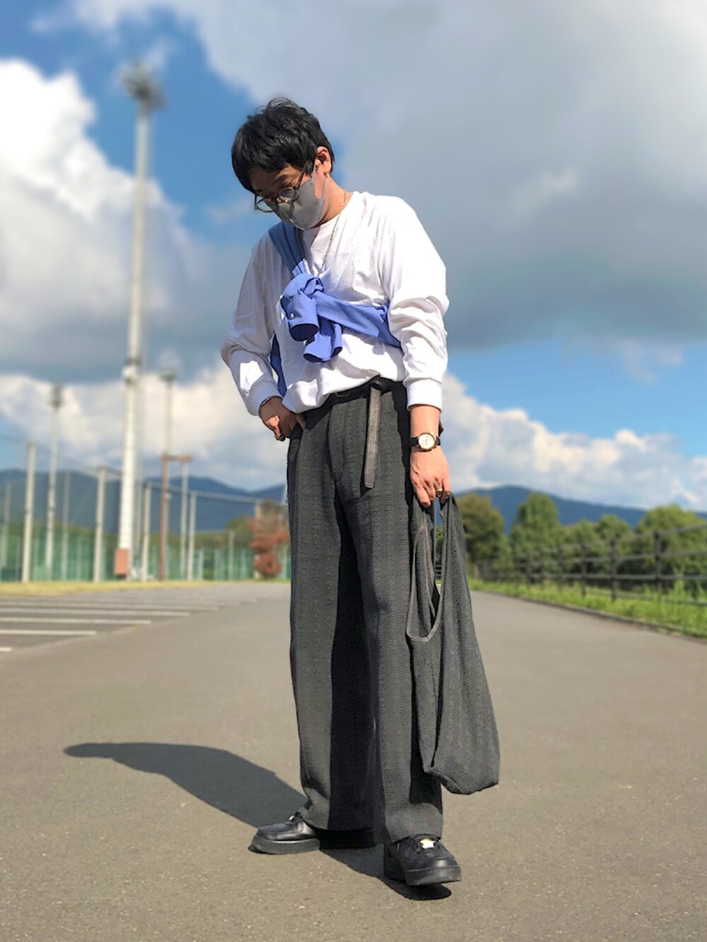 ブルー系のシャツ/ブラウス、グレー系のトートバッグ、グレー系のスラックスを着用したメンズの秋コーディネートの2枚目の写真