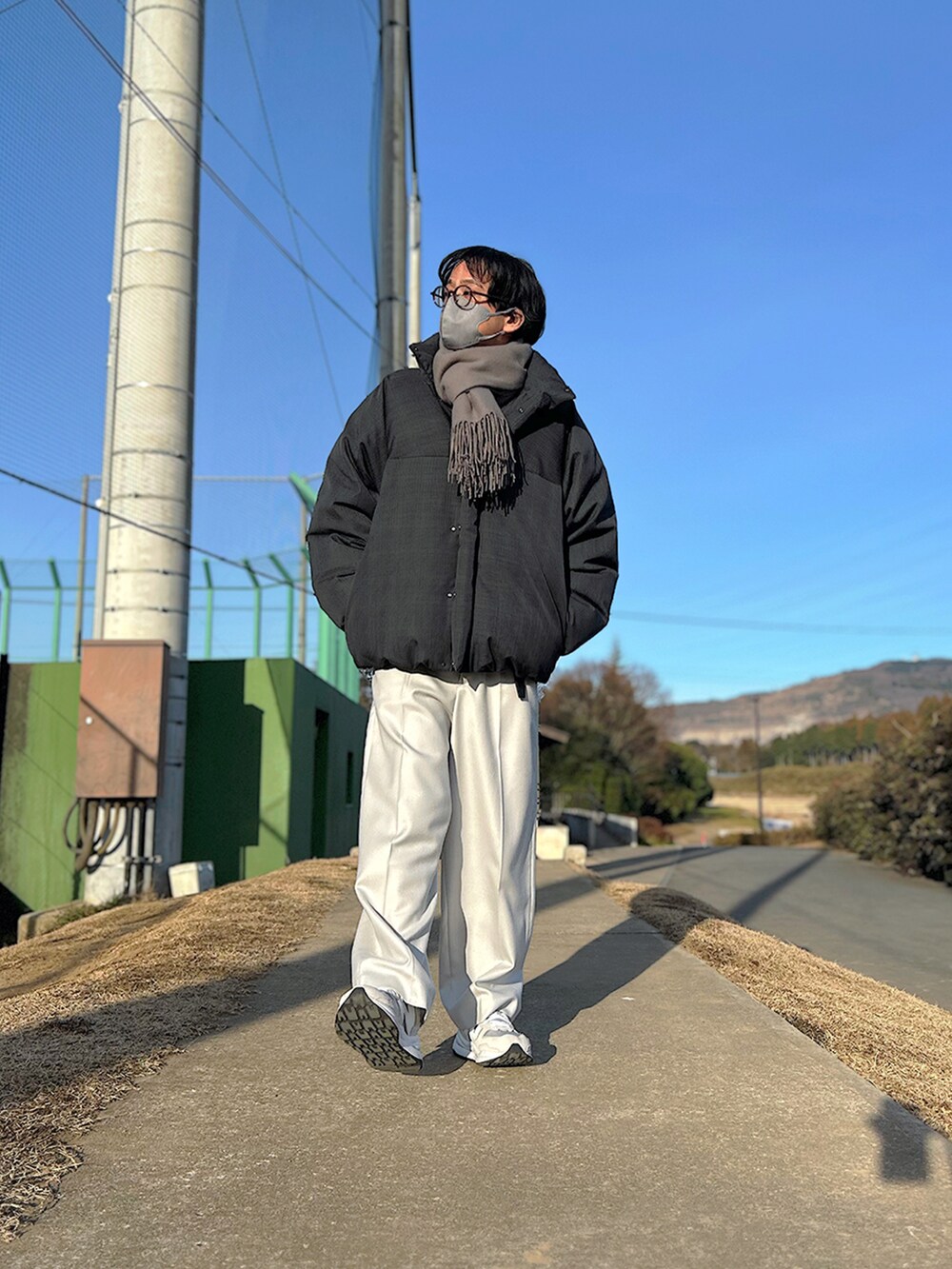 グレー系のダウンジャケット/コート、オレンジ系のシャツ/ブラウス、ブラック系のショルダーバッグを着用したメンズの冬コーディネートの2枚目の写真