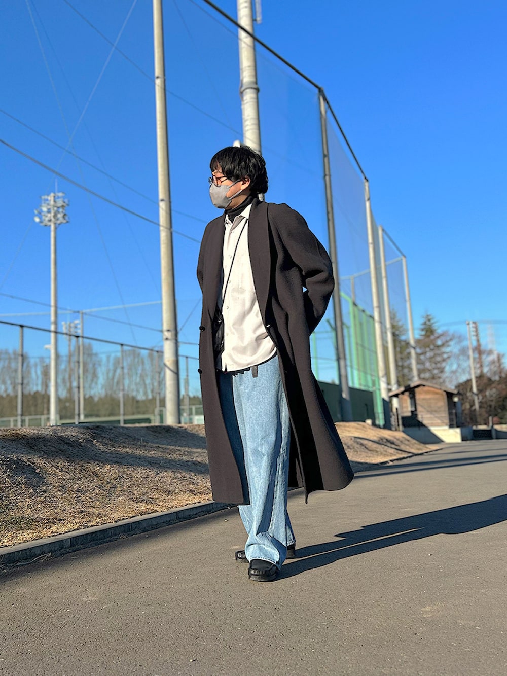 ホワイト系のシャツ/ブラウス、グレー系のチェスターコート、ブラック系のショルダーバッグを着用したメンズの冬コーディネートの2枚目の写真