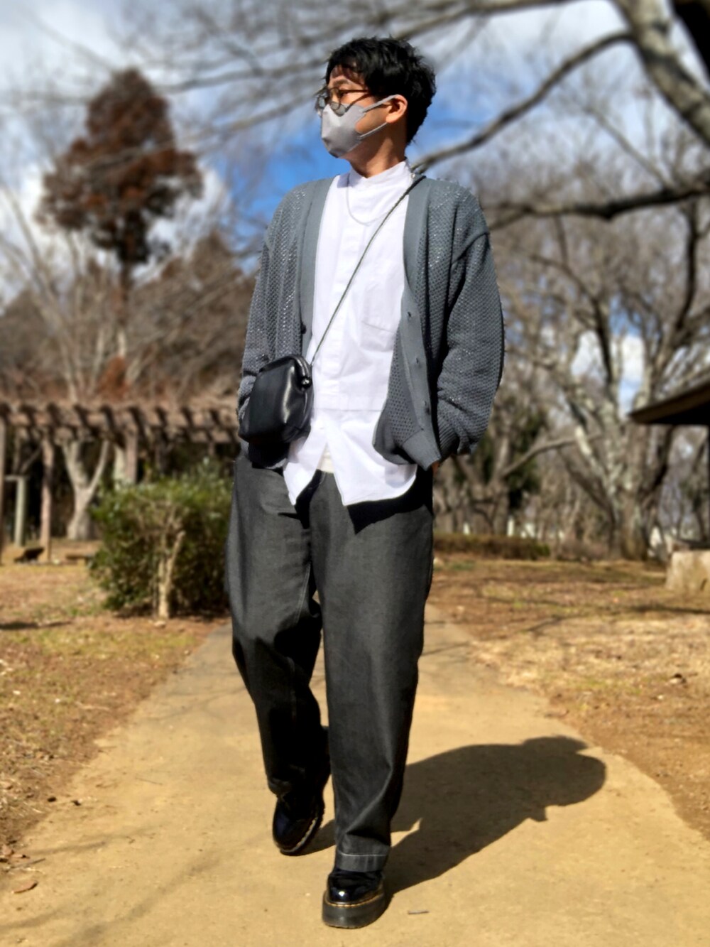 グリーン系のカーディガン/ボレロ、グレー系のトレンチコート、ブラック系のドレスシューズを着用したメンズの冬コーディネートの3枚目の写真