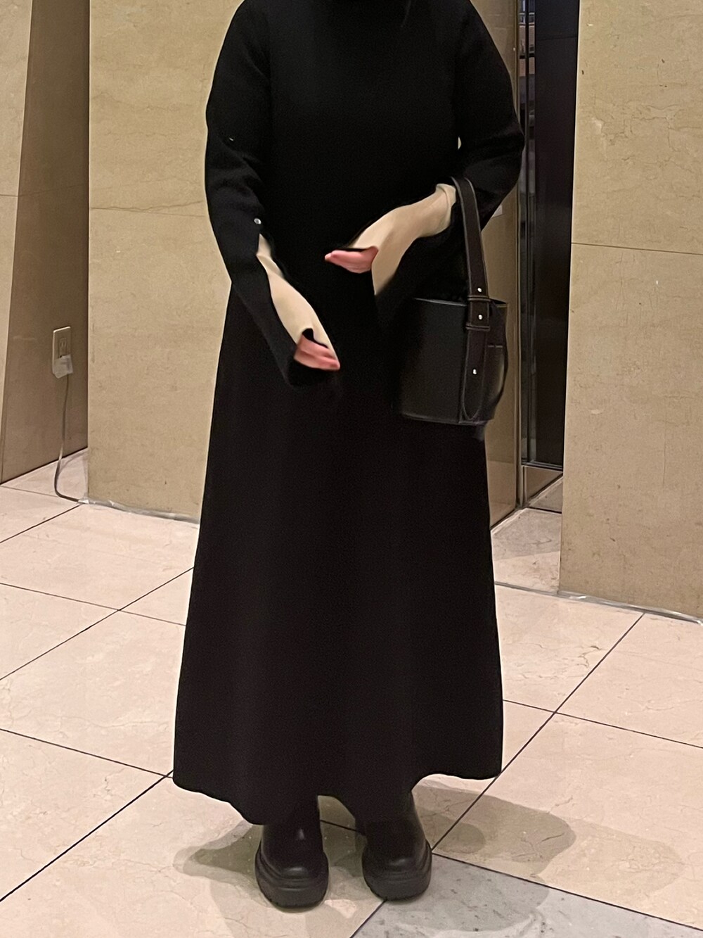 ブラック系のワンピースを着用したレディースの秋コーディネートの2枚目の写真