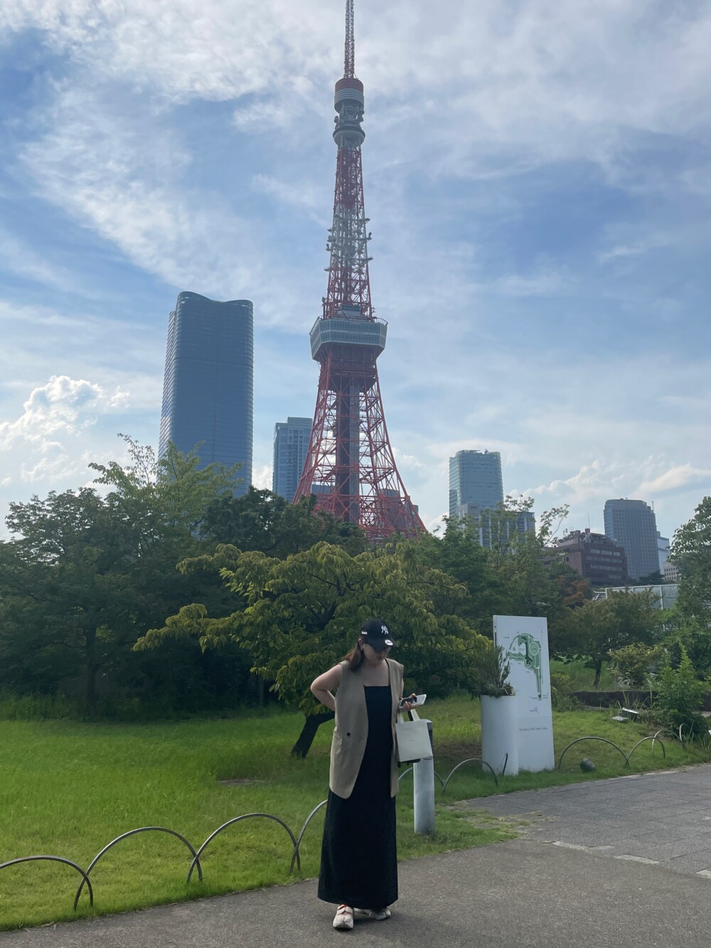 ブラック系のワンピース、ベージュ系のベスト、ベージュ系のサンダルを着用したレディースの夏コーディネートの3枚目の写真
