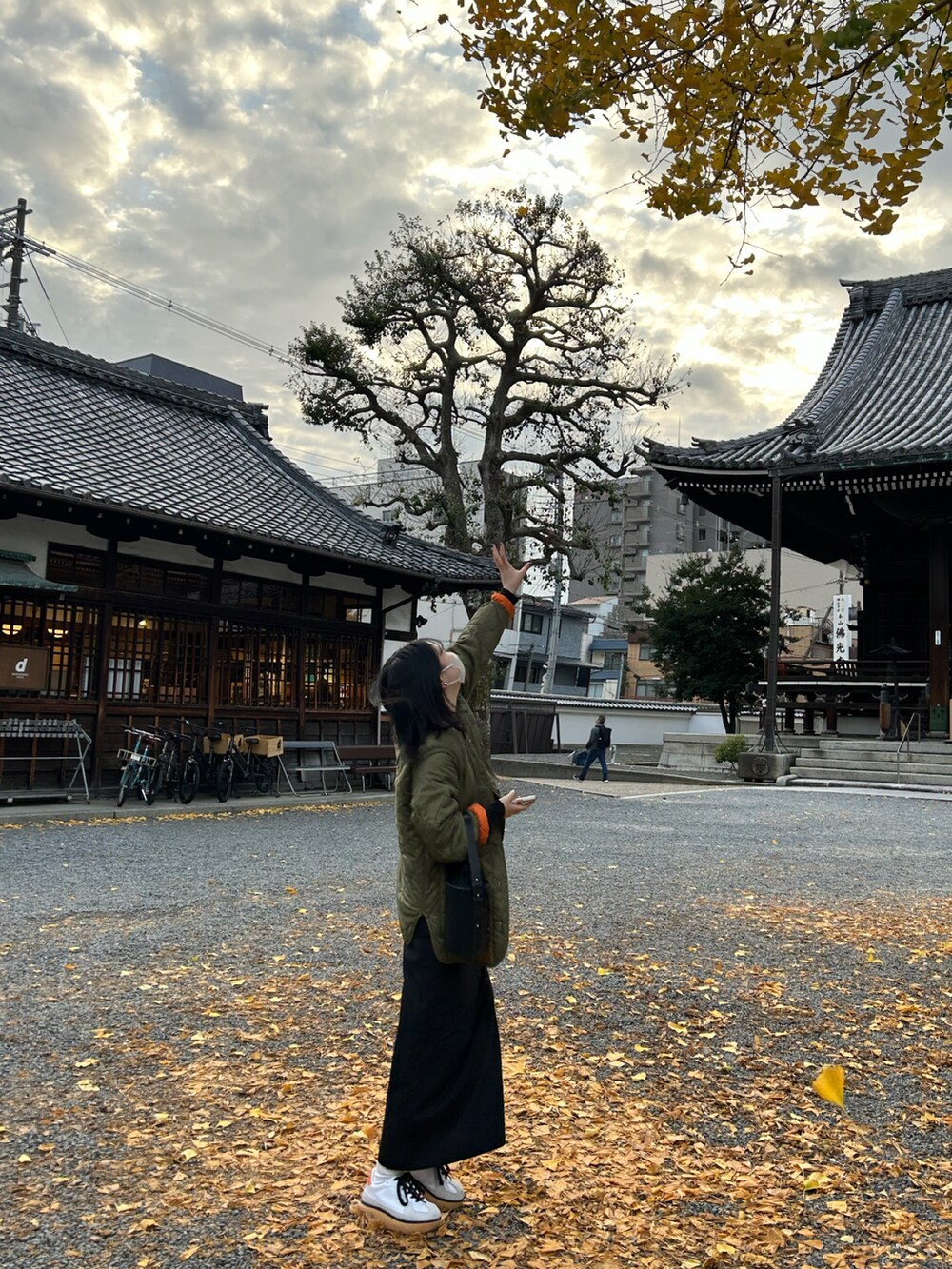 グリーン系のその他アウター、ホワイト系のスニーカーを着用したレディースの冬コーディネートの2枚目の写真