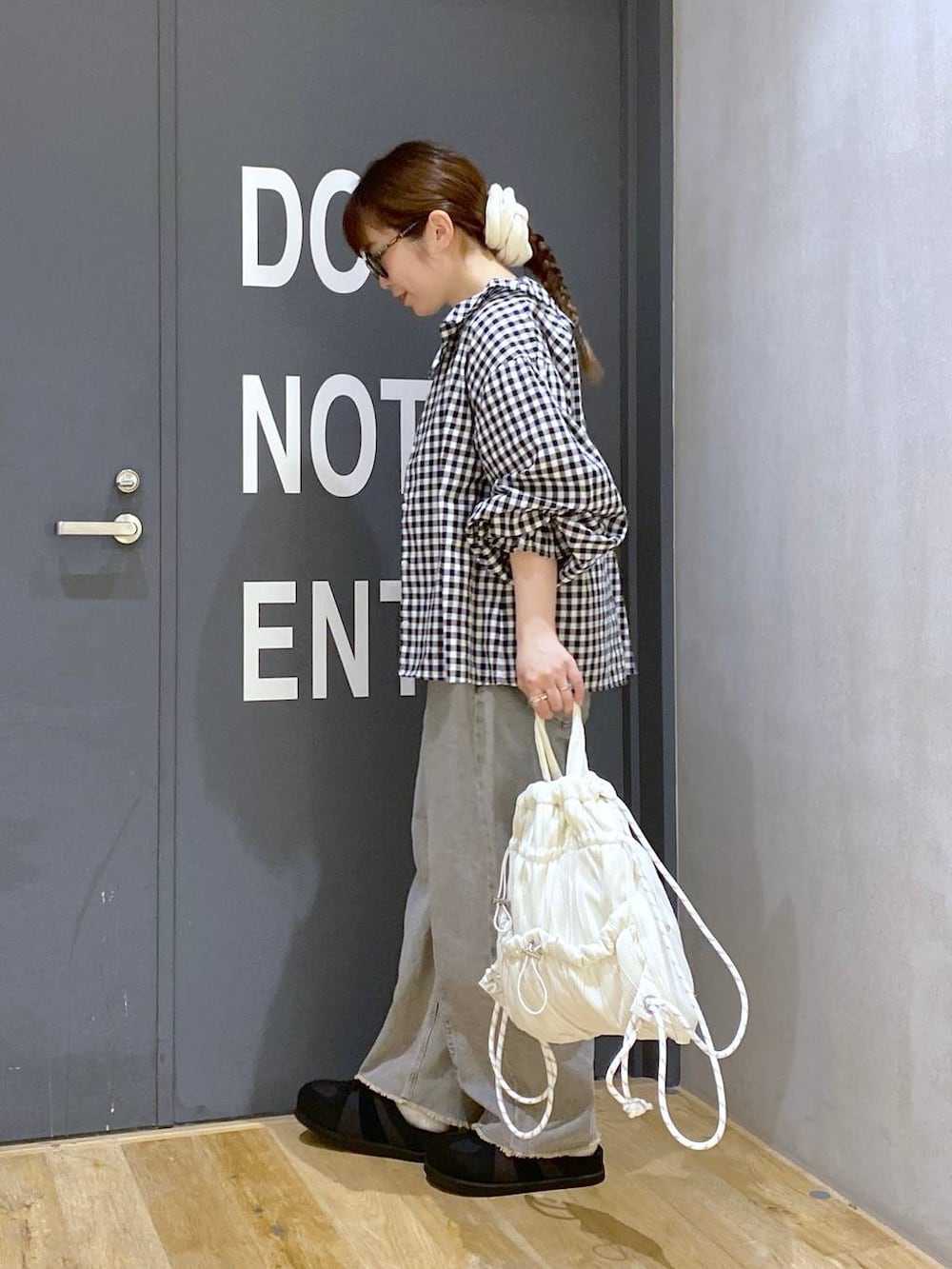 ピンク系のデニムパンツ、ブラック系のシャツ/ブラウス、ブラック系のスニーカーを着用したレディースの春コーディネートの3枚目の写真