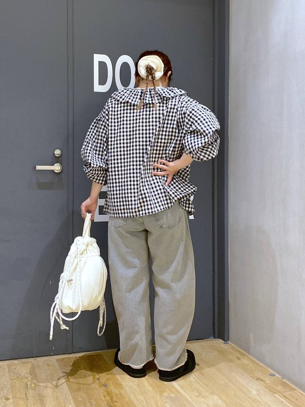 ピンク系のデニムパンツ、ブラック系のシャツ/ブラウス、ブラック系のスニーカーを着用したレディースの春コーディネートの4枚目の写真