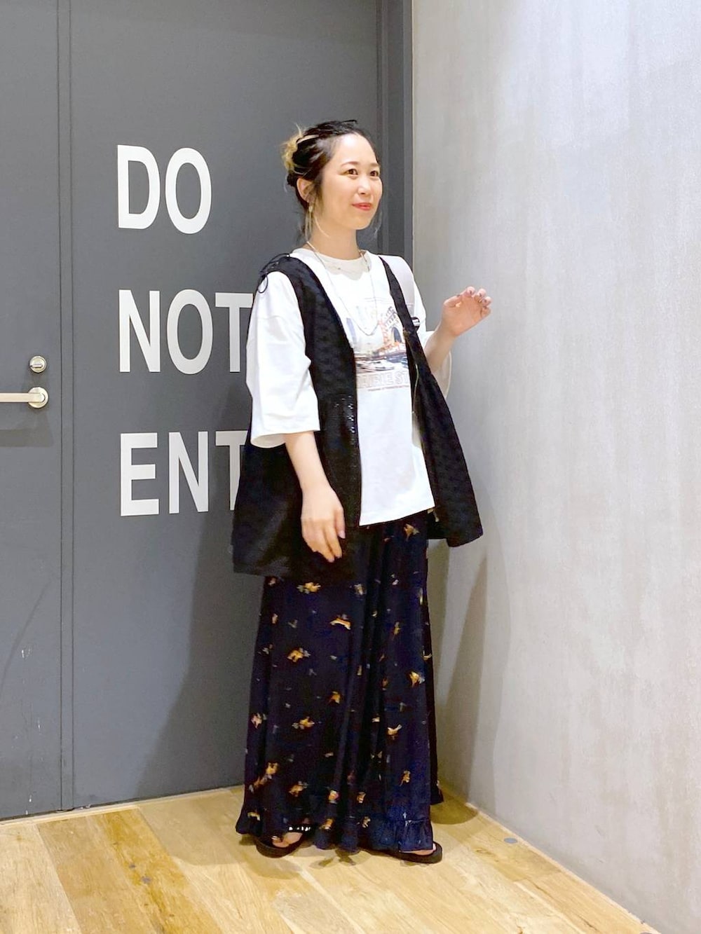 グレー系のバックパック/リュック、ブラック系のベスト、ホワイト系のTシャツ/カットソーを着用したレディースの夏コーディネートの3枚目の写真