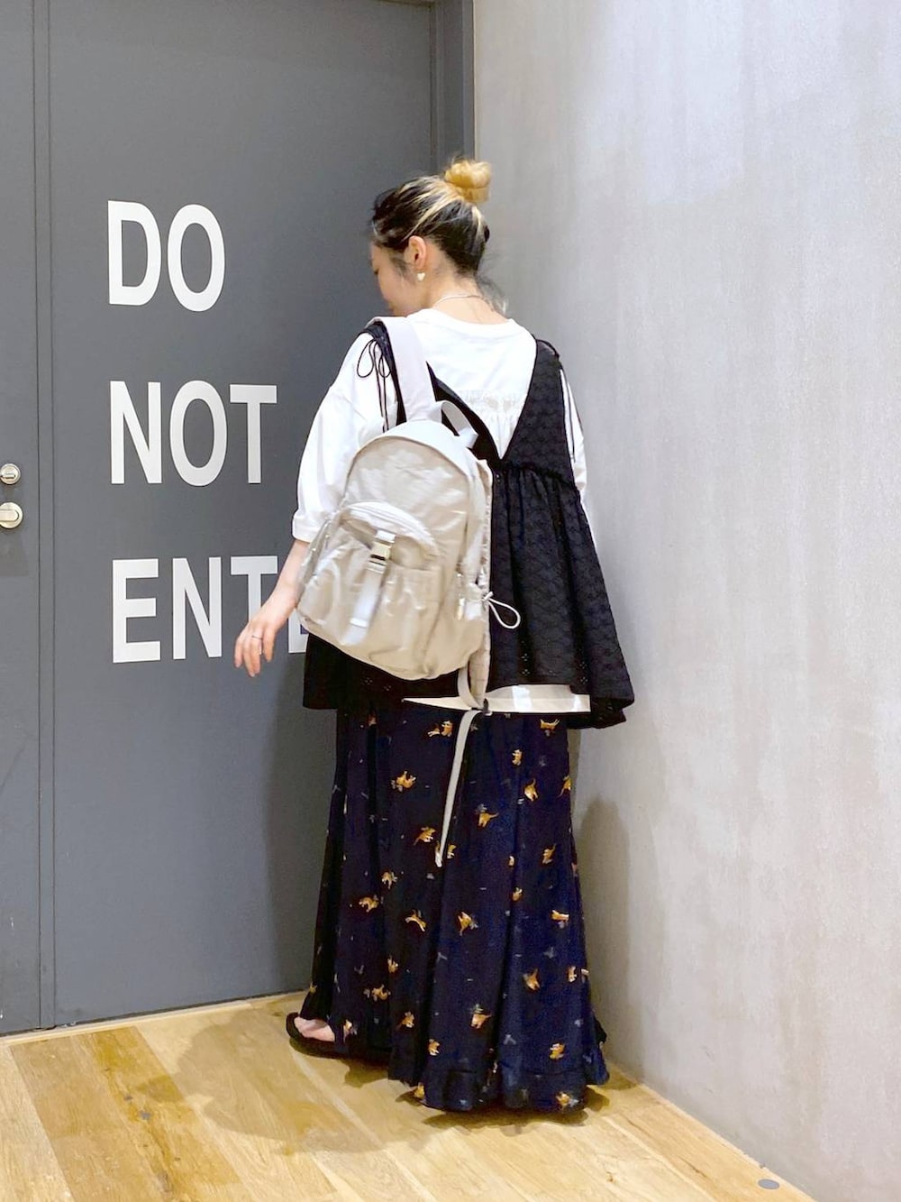 グレー系のバックパック/リュック、ブラック系のベスト、ホワイト系のTシャツ/カットソーを着用したレディースの夏コーディネートの4枚目の写真