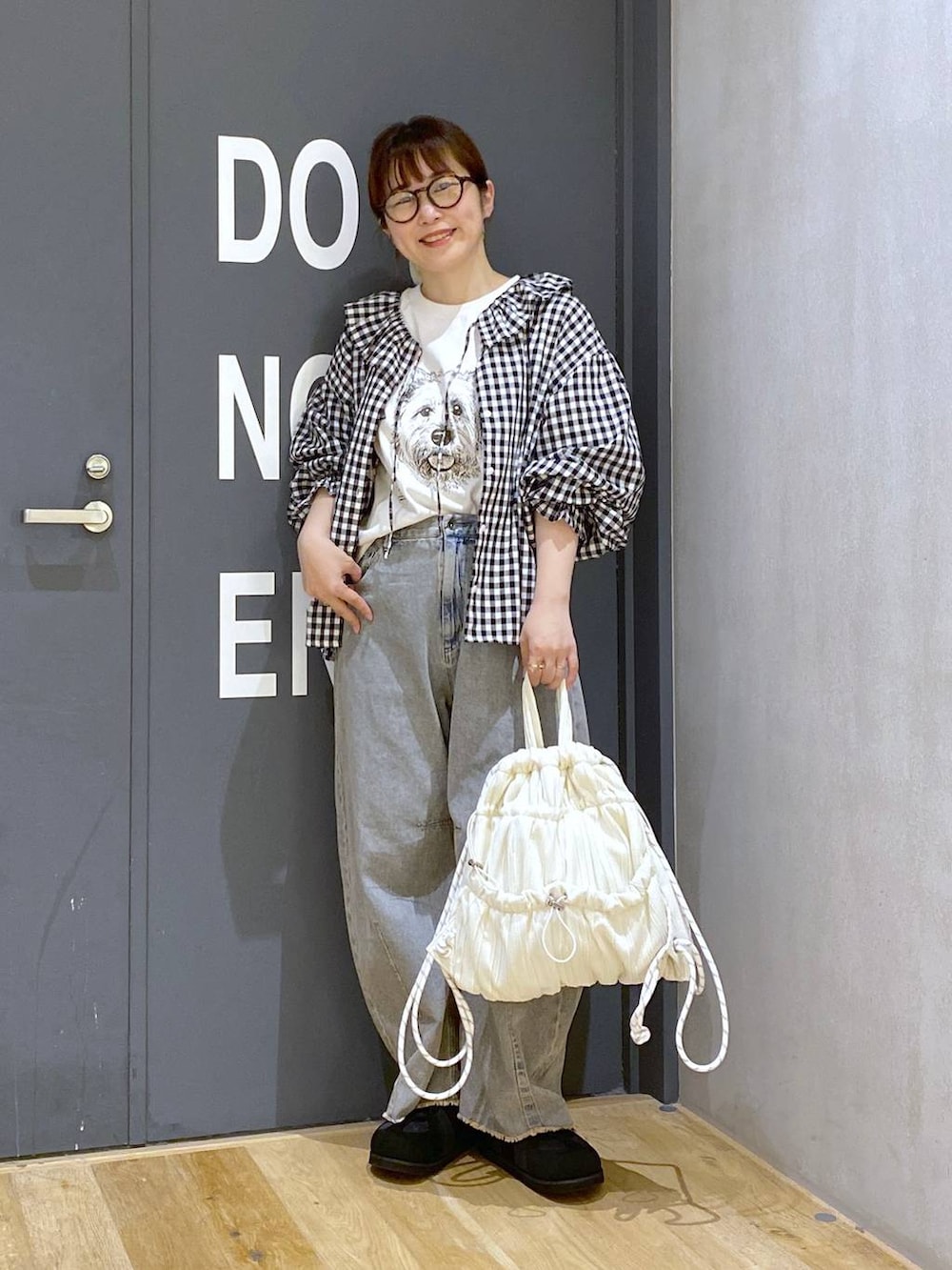 ピンク系のデニムパンツ、ブラック系のシャツ/ブラウス、ブラック系のスニーカーを着用したレディースの春コーディネートの2枚目の写真