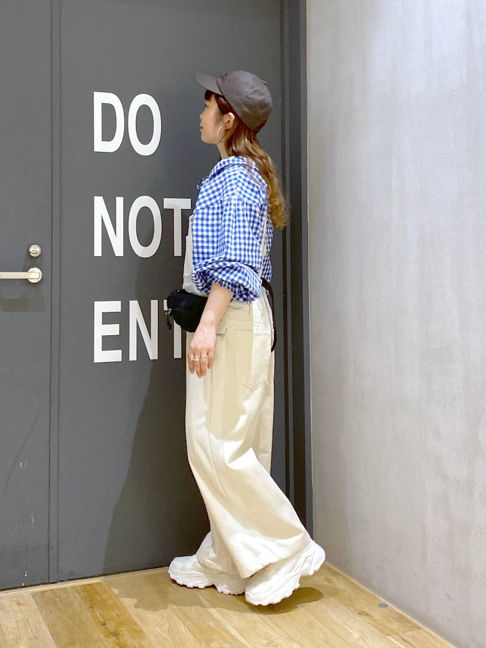 ベージュ系のスニーカー、ベージュ系のサロペット/オーバーオール、ブルー系のシャツ/ブラウスを着用したレディースの春コーディネートの3枚目の写真