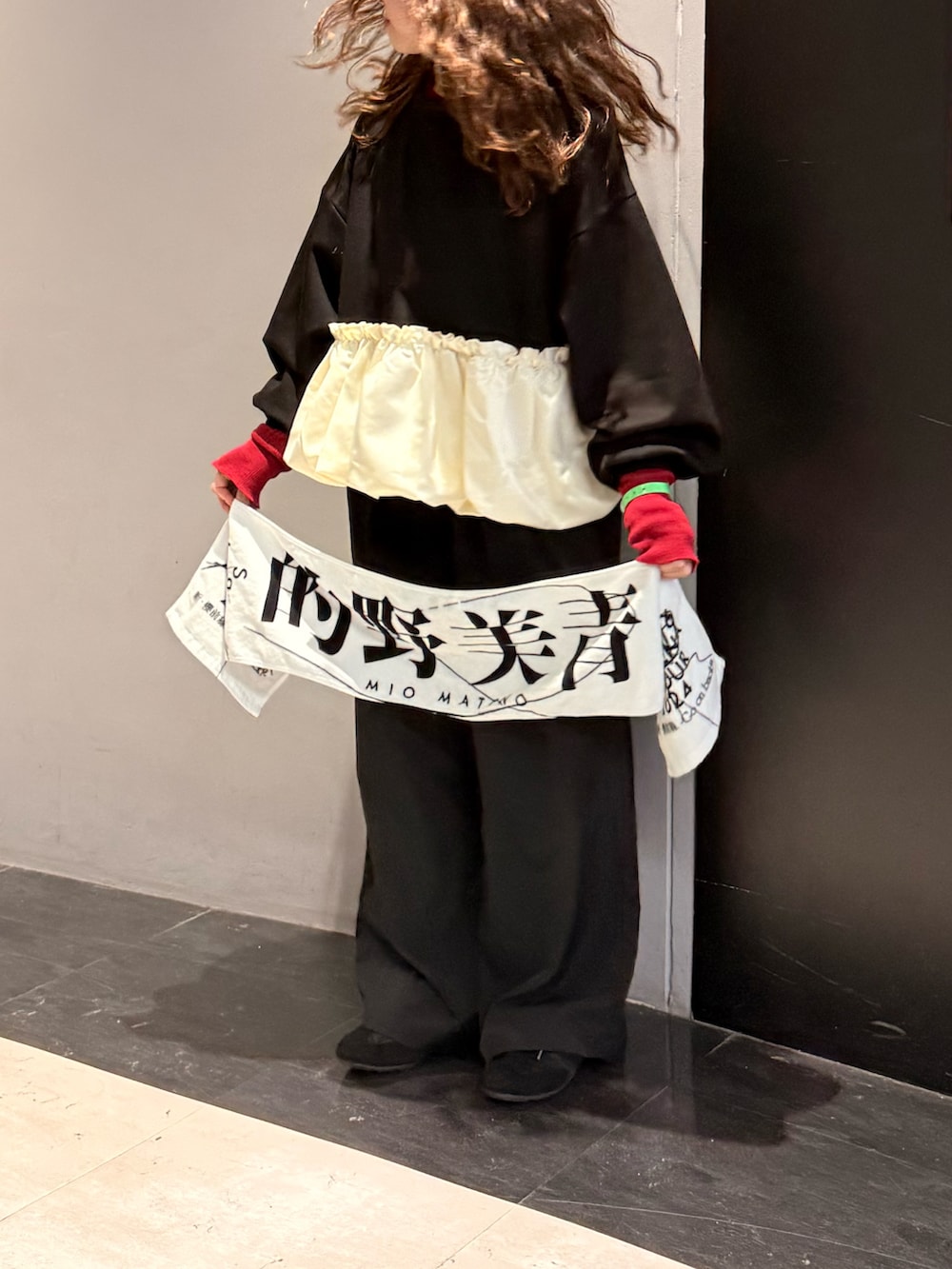 ブラック系のトップス、ブラック系のシューズ、レッド系のニット/セーターを着用したレディースの冬コーディネートの3枚目の写真