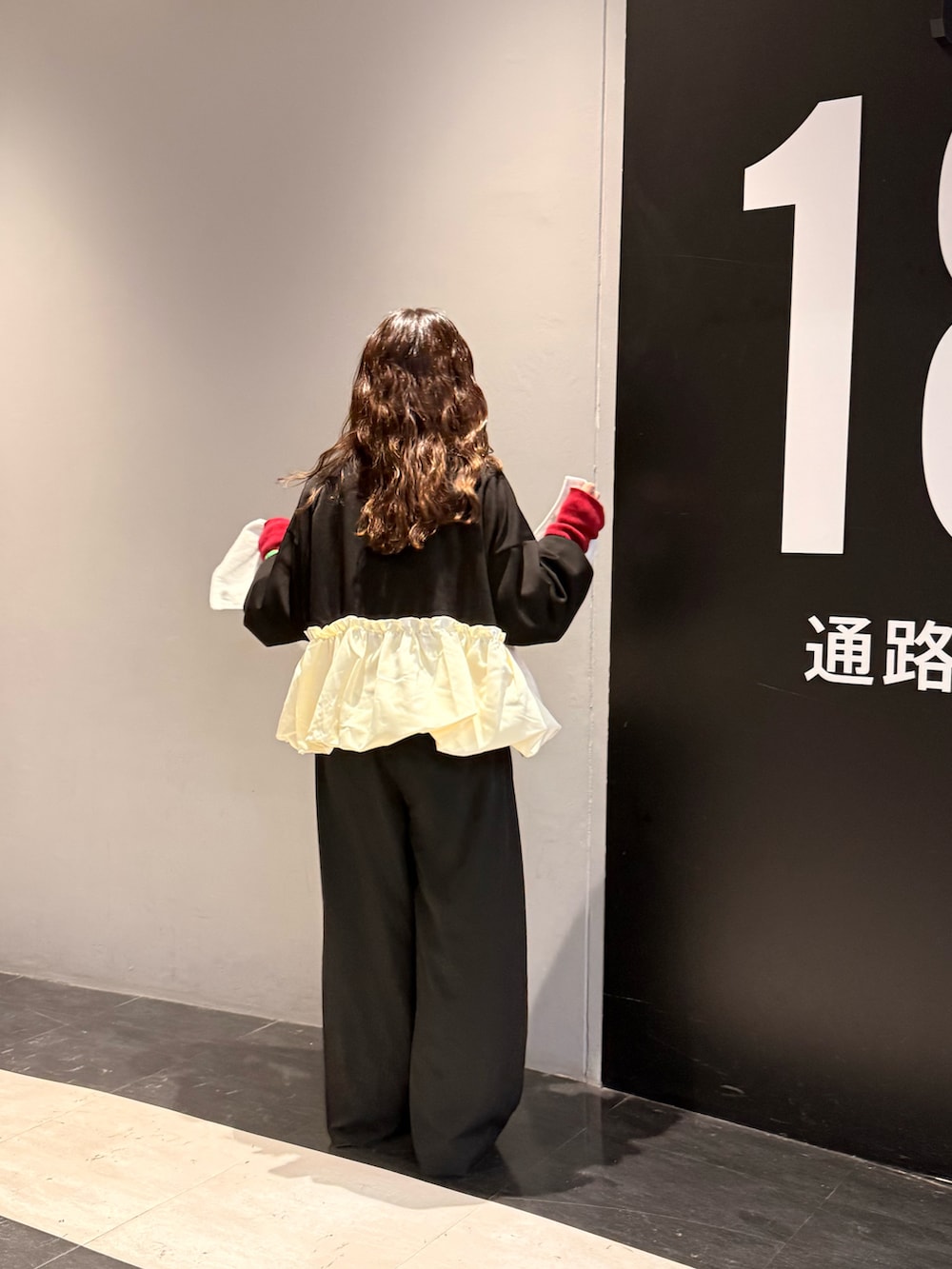 ブラック系のトップス、ブラック系のシューズ、レッド系のニット/セーターを着用したレディースの冬コーディネートの2枚目の写真