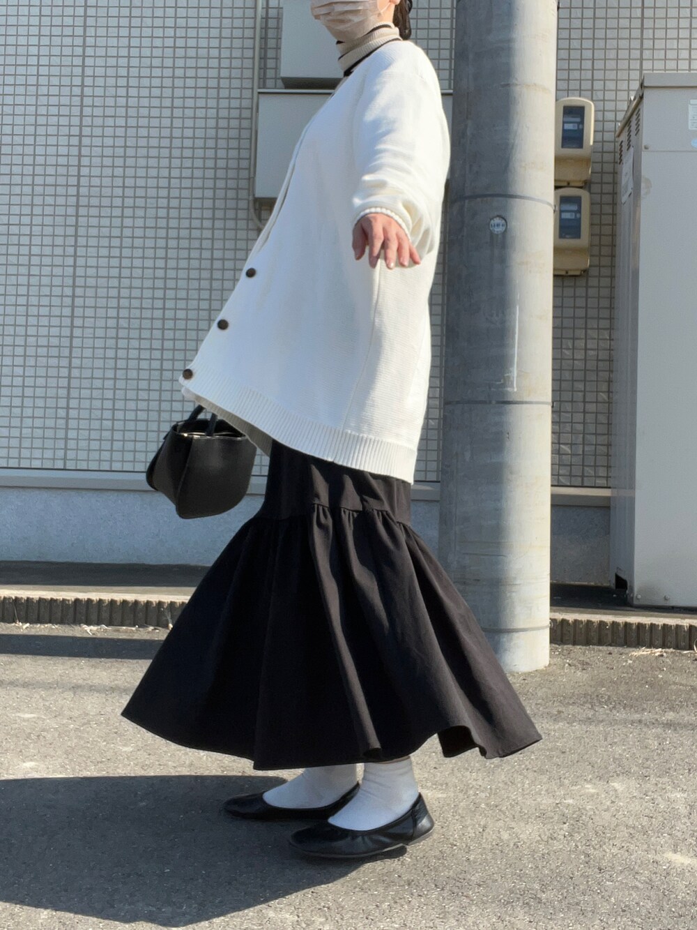 ホワイト系のカーディガン/ボレロ、ホワイト系のニット/セーター、ブラック系のスカートを着用したレディースの秋コーディネートの3枚目の写真