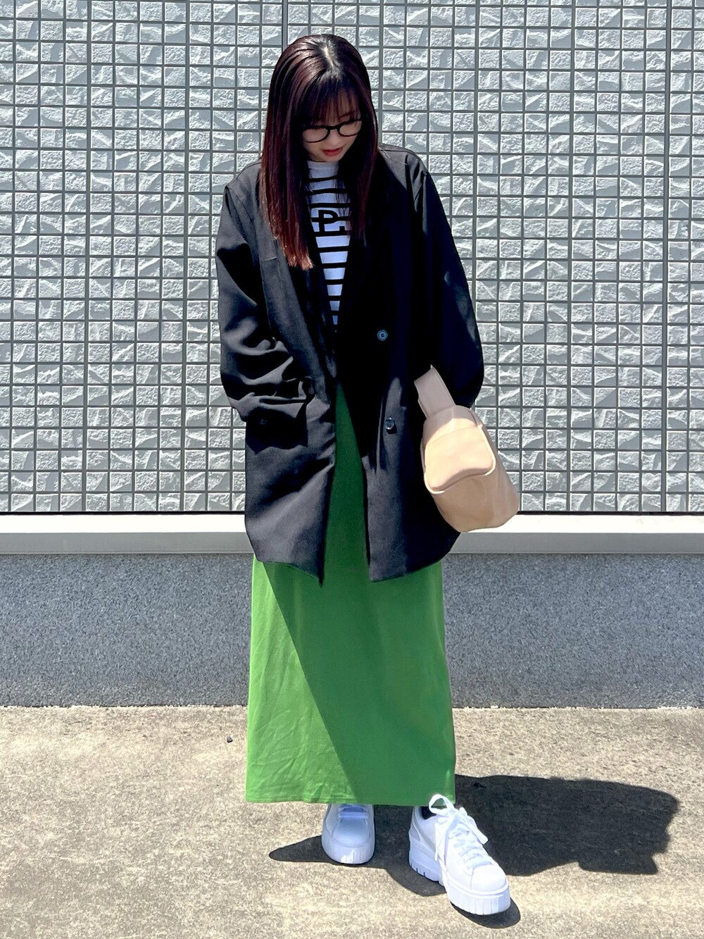 ホワイト系のTシャツ/カットソー、ブラック系のテーラードジャケット、グリーン系のスカートを着用したレディースの春コーディネートの2枚目の写真