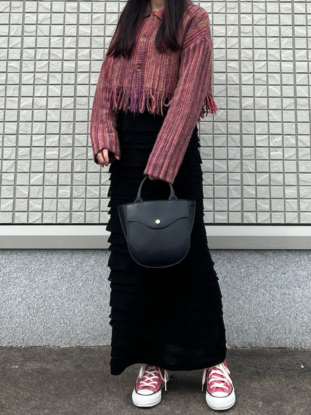 ブラック系のスカート、ピンク系のニット/セーター、ブラック系のショルダーバッグを着用したレディースの春コーディネートの2枚目の写真
