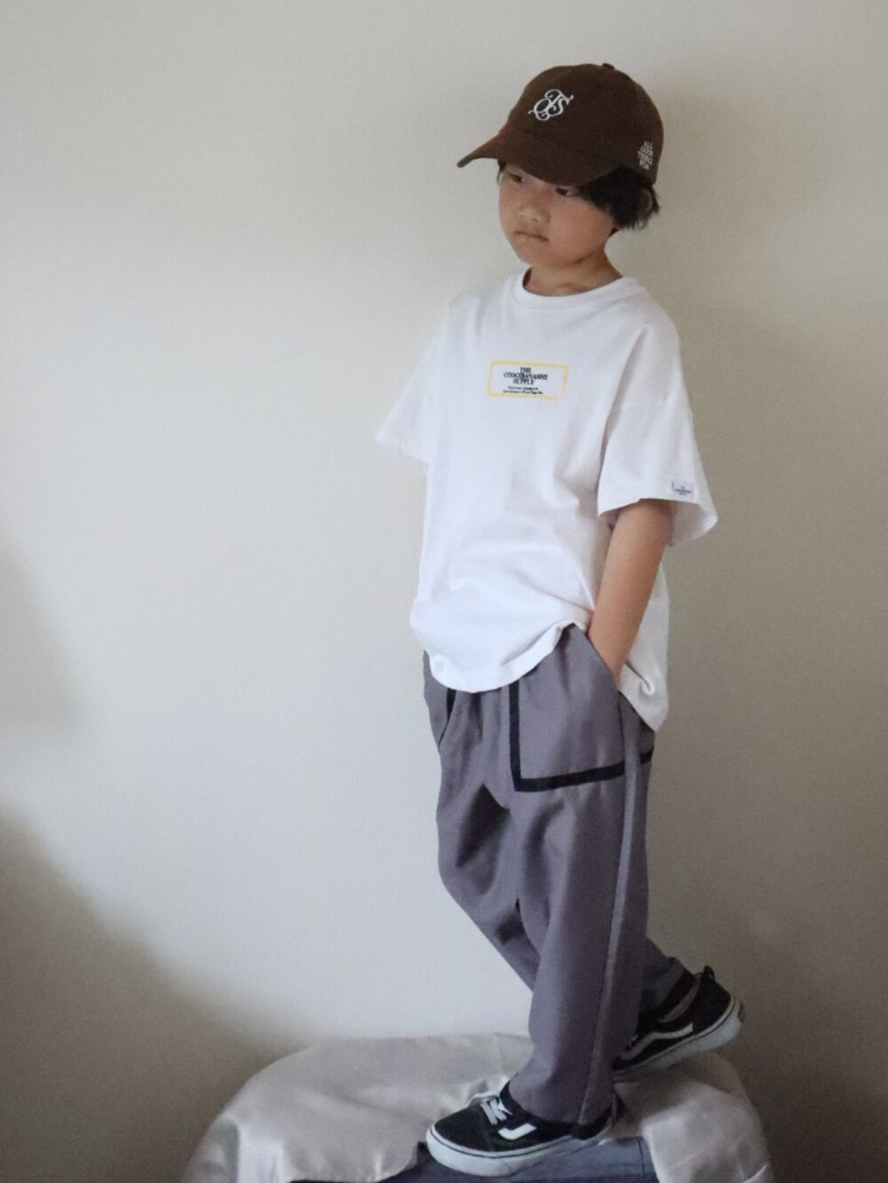 グレー系のTシャツ/カットソー、グレー系のパンツ、ブラック系のスニーカーを着用したキッズの夏コーディネートの2枚目の写真