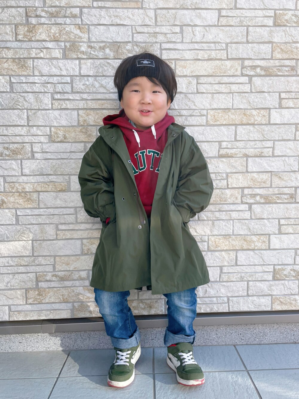 レッド系のパーカー、グリーン系のスニーカー、グリーン系のモッズコートを着用したキッズの冬コーディネートの3枚目の写真