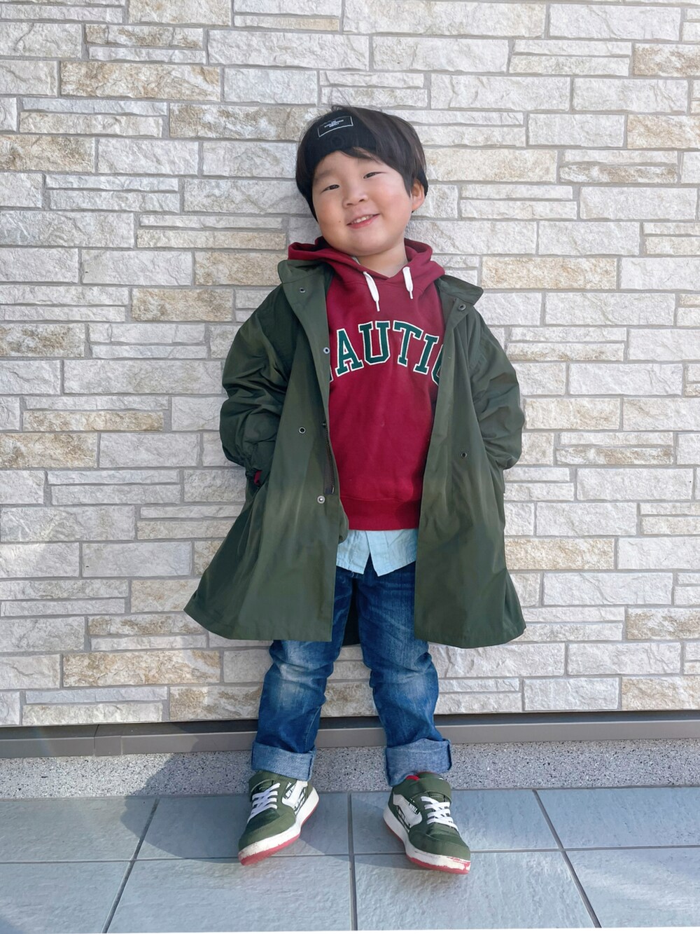 レッド系のパーカー、グリーン系のスニーカー、グリーン系のモッズコートを着用したキッズの冬コーディネートの2枚目の写真