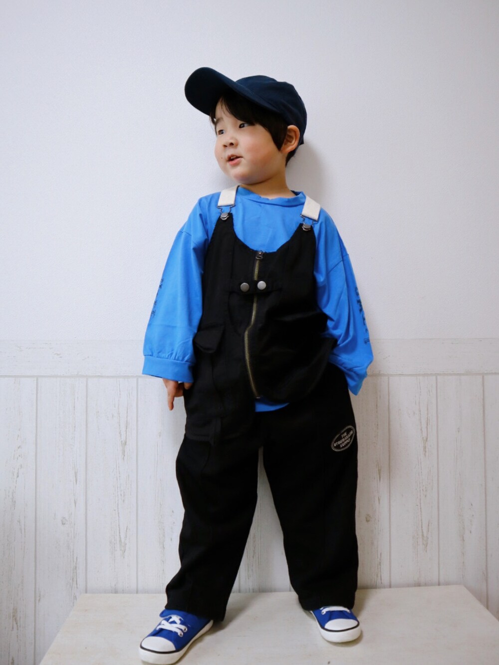 ブラック系のベスト、ブラック系のスウェットパンツ、ブルー系のスニーカーを着用したキッズの春コーディネートの3枚目の写真