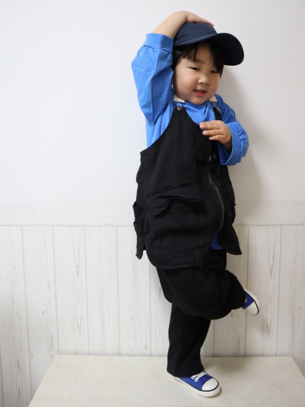 ブラック系のベスト、ブラック系のスウェットパンツ、ブルー系のスニーカーを着用したキッズの春コーディネートの5枚目の写真