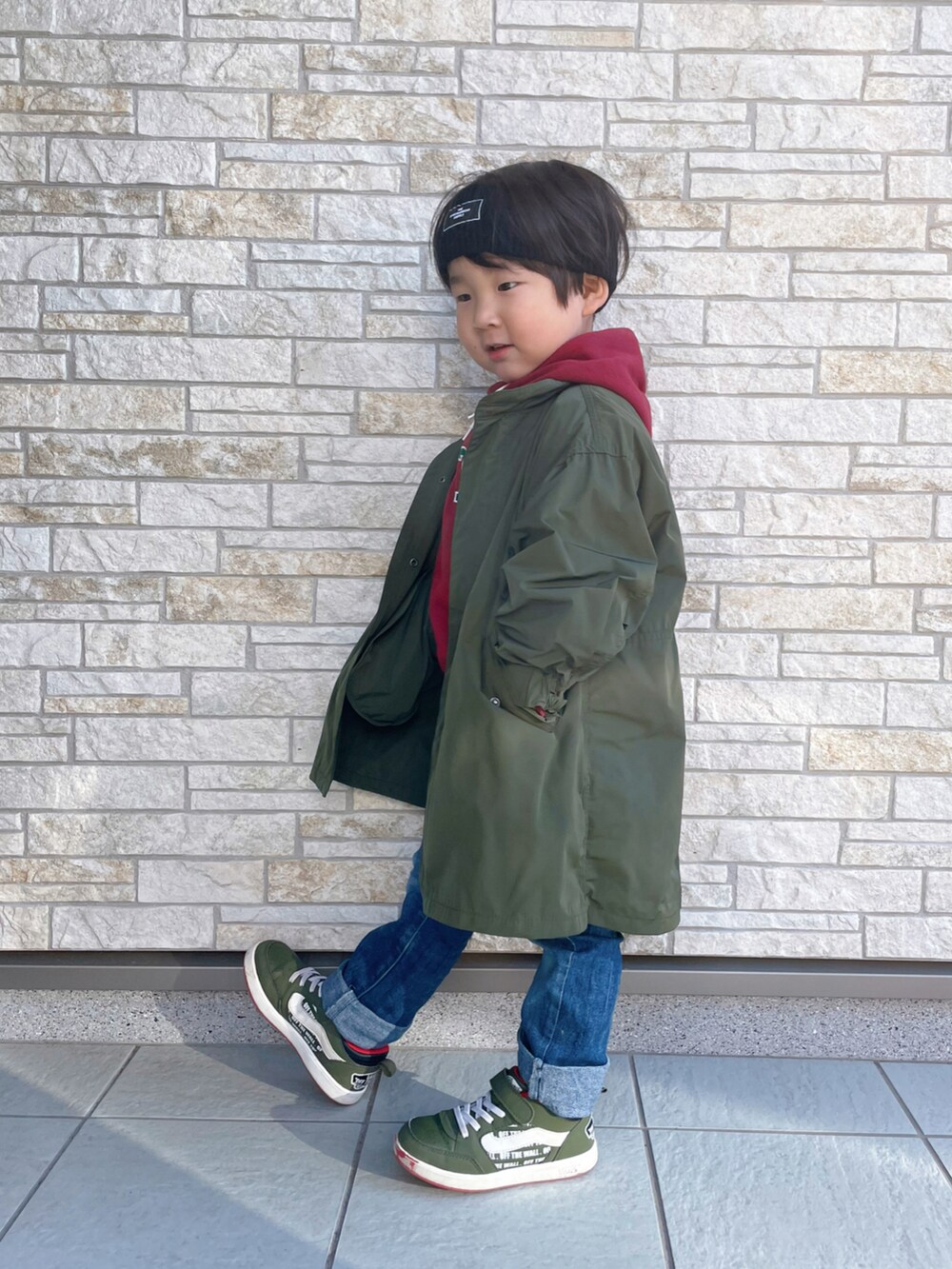レッド系のパーカー、グリーン系のスニーカー、グリーン系のモッズコートを着用したキッズの冬コーディネートの4枚目の写真