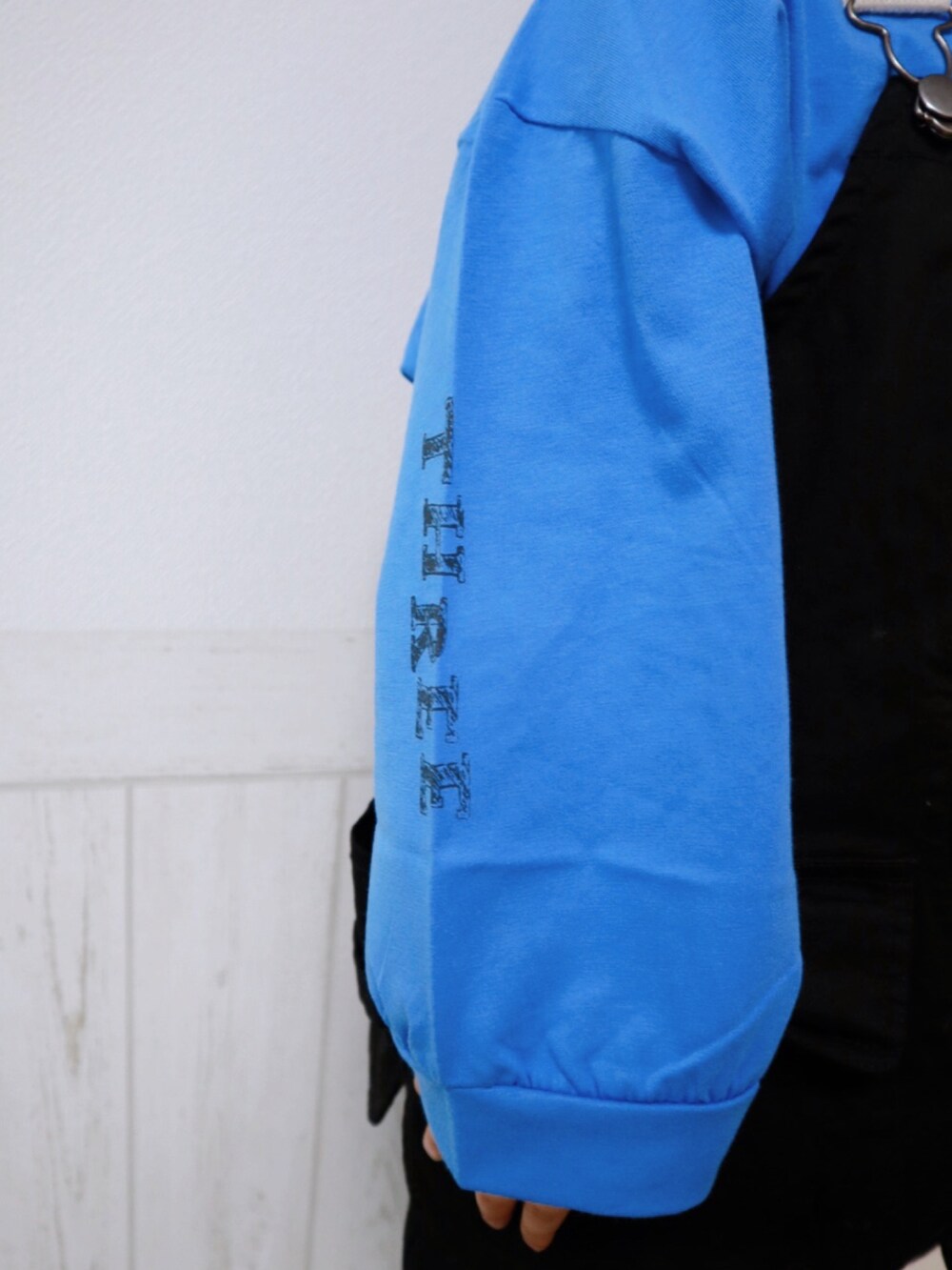 ブラック系のベスト、ブラック系のスウェットパンツ、ブルー系のスニーカーを着用したキッズの春コーディネートの4枚目の写真