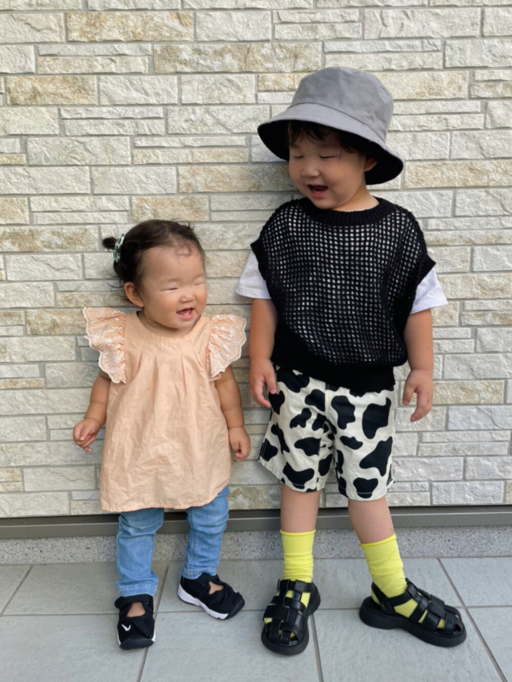 ブラック系のベスト、ホワイト系のその他パンツ、ブラック系のサンダルを着用したキッズの夏コーディネートの2枚目の写真