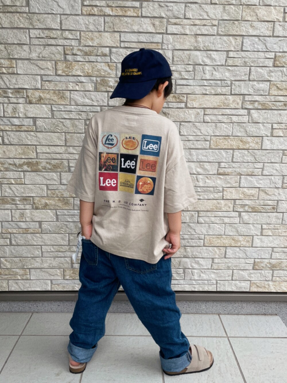 グレー系のTシャツ/カットソー、ブルー系のデニムパンツ、ベージュ系のサンダルを着用したキッズの夏コーディネートの2枚目の写真