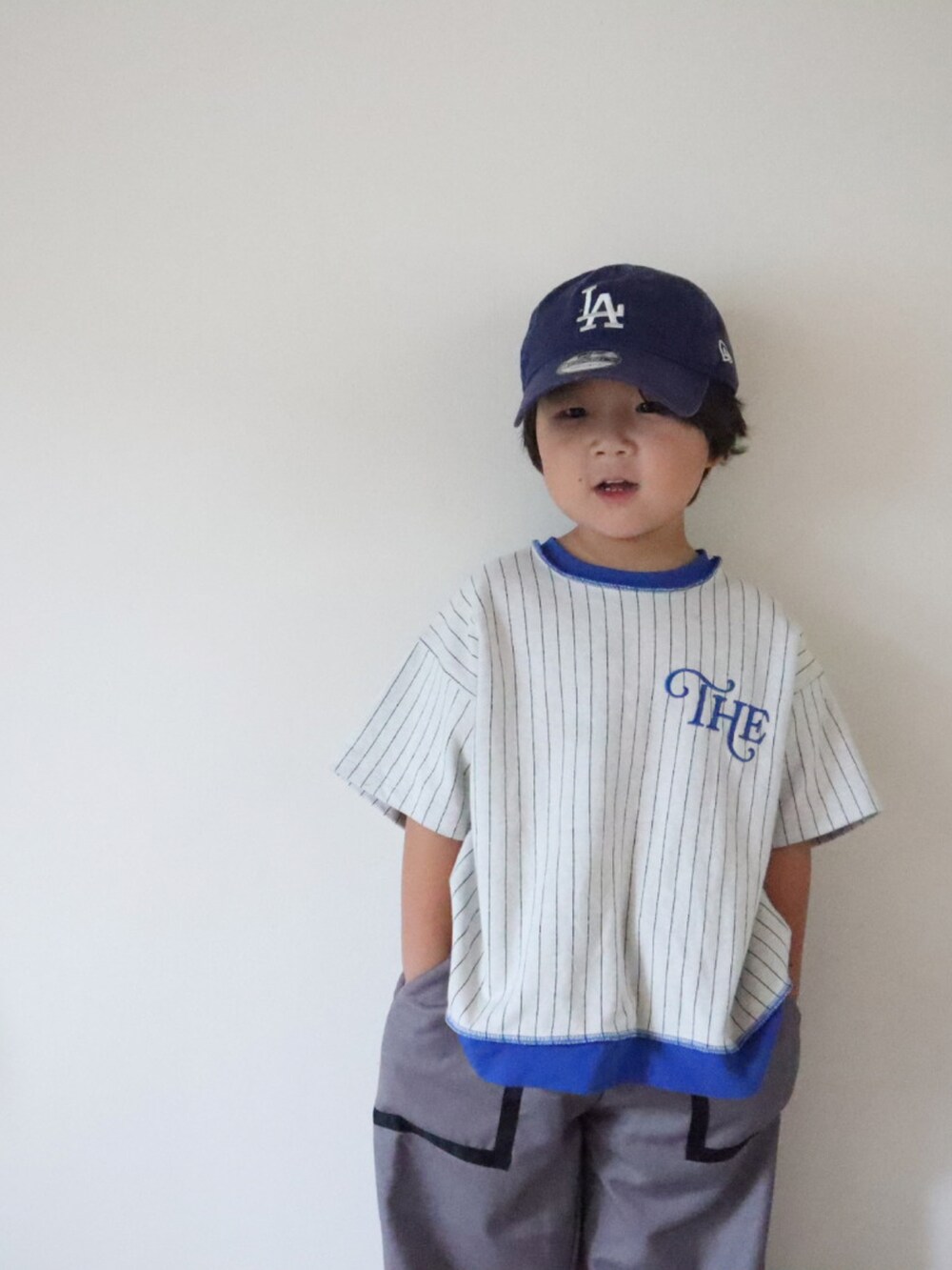 グレー系のTシャツ/カットソー、グレー系のパンツ、ベージュ系のスニーカーを着用したキッズの夏コーディネートの5枚目の写真