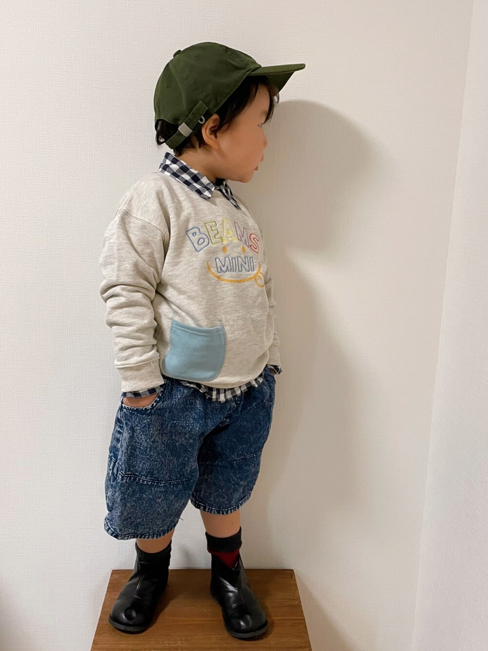 ホワイト系のスウェット、ブルー系のデニムパンツ、ブラック系のブーツを着用したキッズの秋コーディネートの3枚目の写真