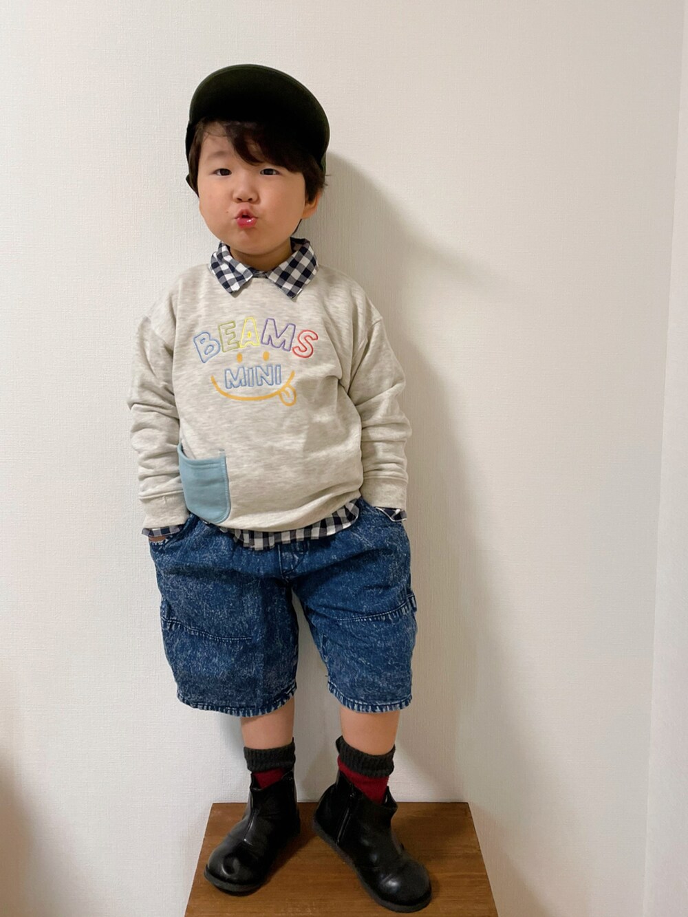 ホワイト系のスウェット、ブルー系のデニムパンツ、ブラック系のブーツを着用したキッズの秋コーディネートの2枚目の写真