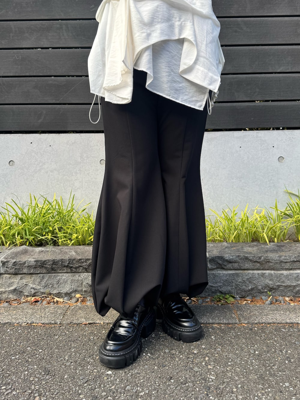 グレー系のニット/セーター、ホワイト系のシャツ/ブラウス、グレー系のその他パンツを着用したレディースの秋コーディネートの6枚目の写真