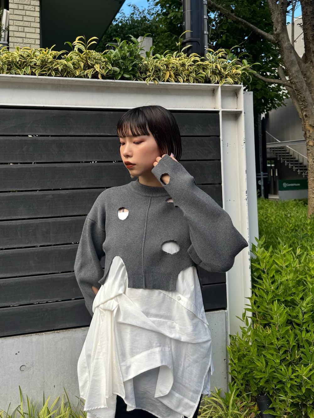 グレー系のニット/セーター、ホワイト系のシャツ/ブラウス、グレー系のその他パンツを着用したレディースの秋コーディネートの2枚目の写真