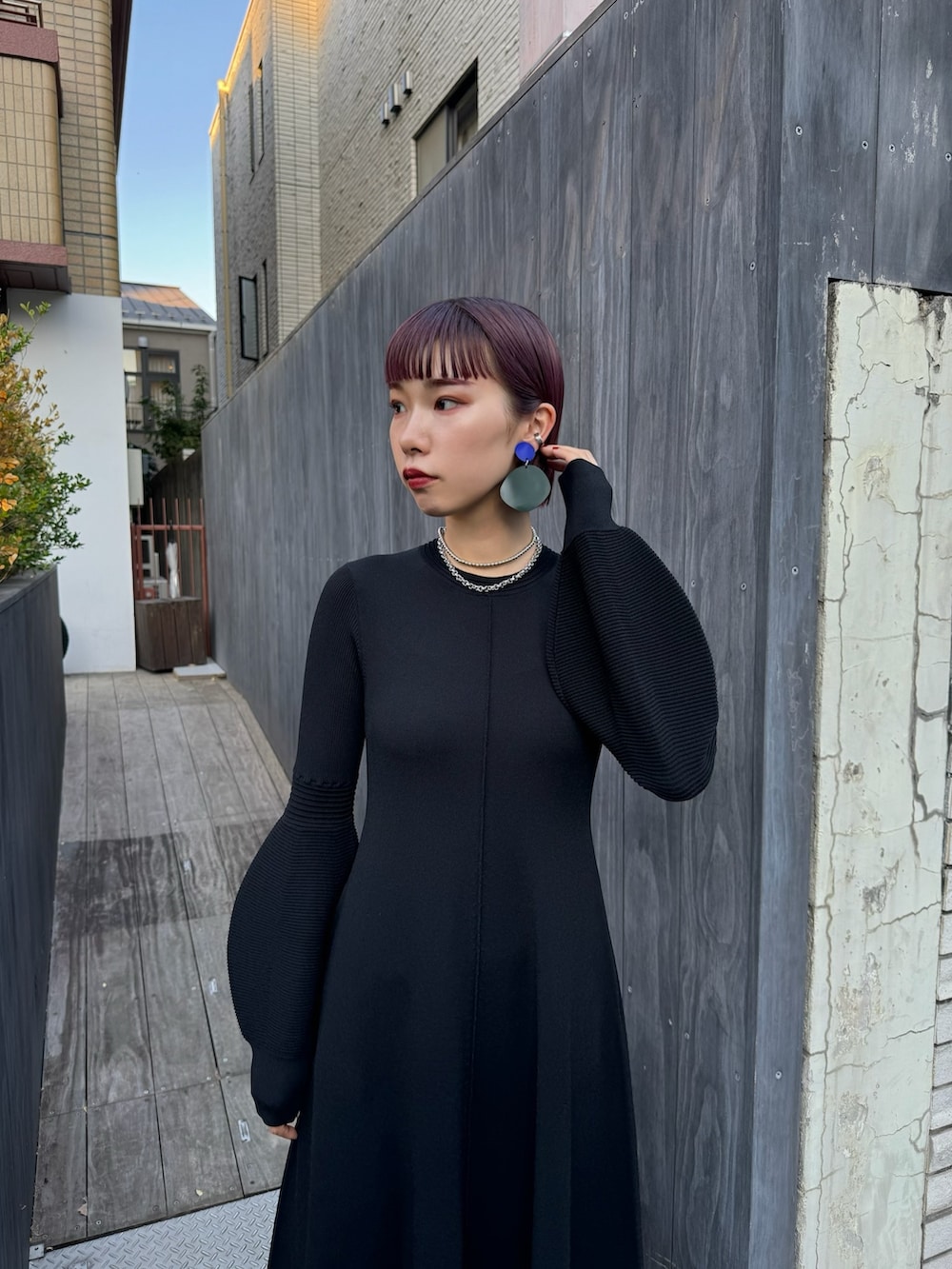 ブラック系のワンピース、シルバー系のブーツ、シルバー系のネックレスを着用したレディースの春コーディネートの2枚目の写真