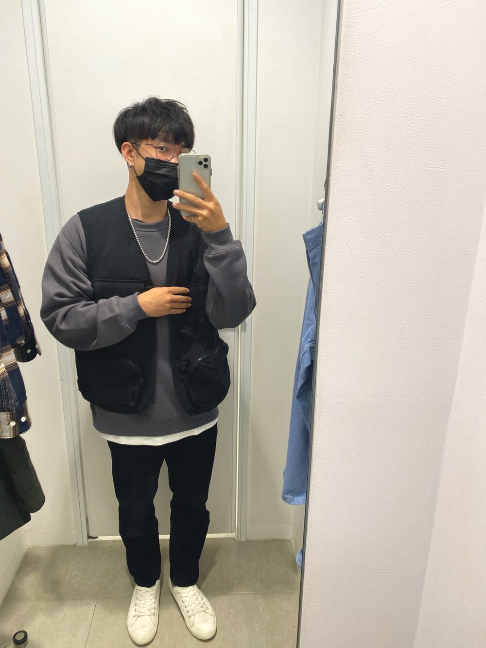 ホワイト系のTシャツ/カットソー、ブラック系のベスト、ブルー系のデニムパンツを着用したメンズの秋コーディネートの2枚目の写真