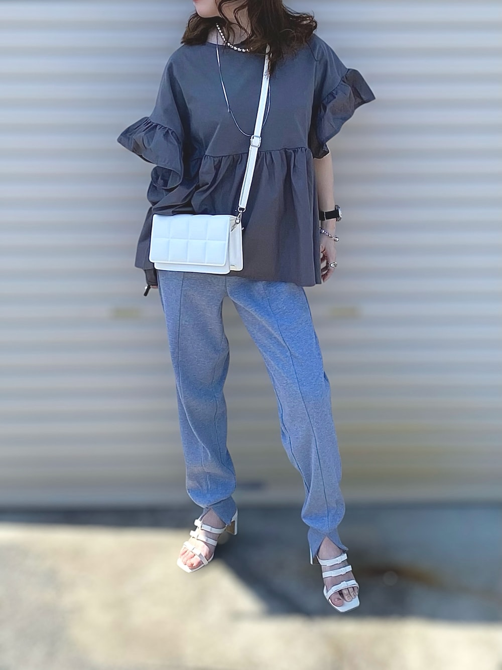 グレー系のTシャツ/カットソー、グレー系のその他パンツ、ホワイト系のサンダルを着用したレディースの夏コーディネートの2枚目の写真