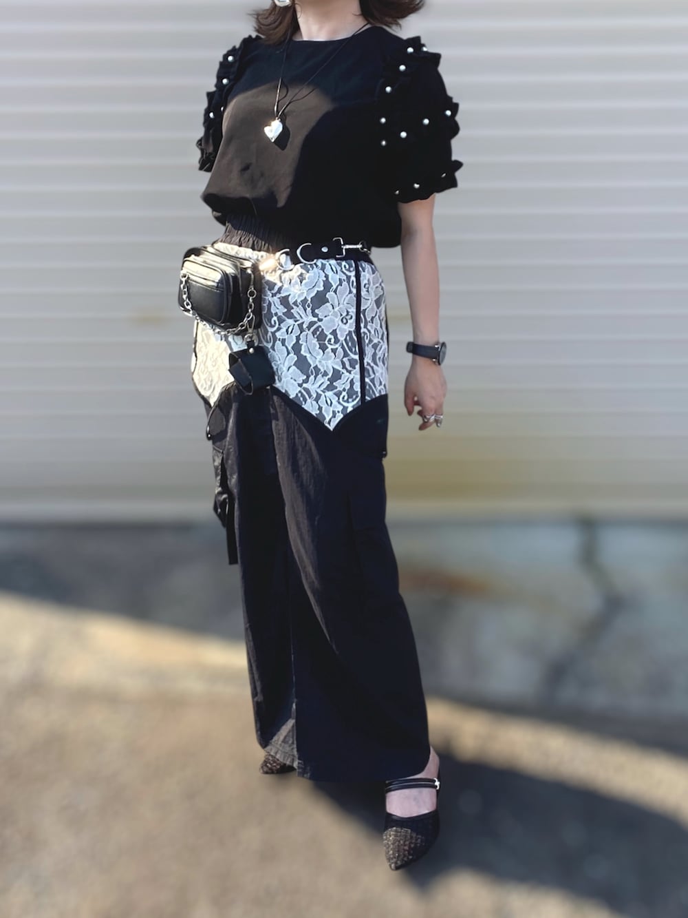 ブラック系のTシャツ/カットソー、ブラック系のスカート、ブラック系のパンプスを着用したレディースの夏コーディネートの3枚目の写真