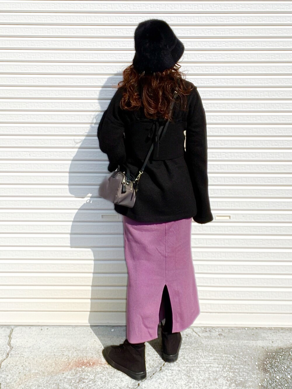 ブラック系のニット/セーター、パープル系のスカート、グレー系のショルダーバッグを着用したレディースの冬コーディネートの5枚目の写真