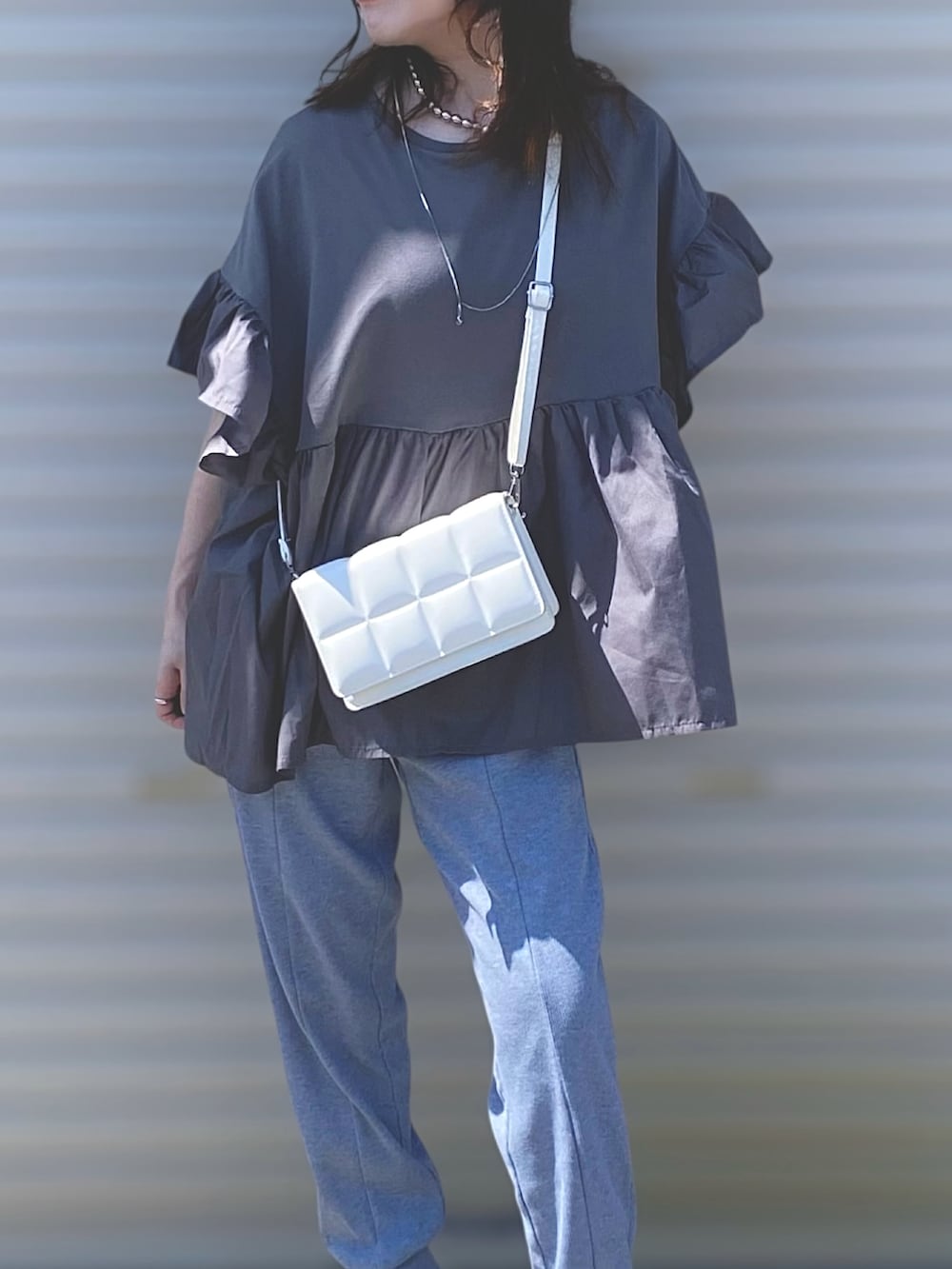 グレー系のTシャツ/カットソー、グレー系のその他パンツ、ホワイト系のサンダルを着用したレディースの夏コーディネートの4枚目の写真