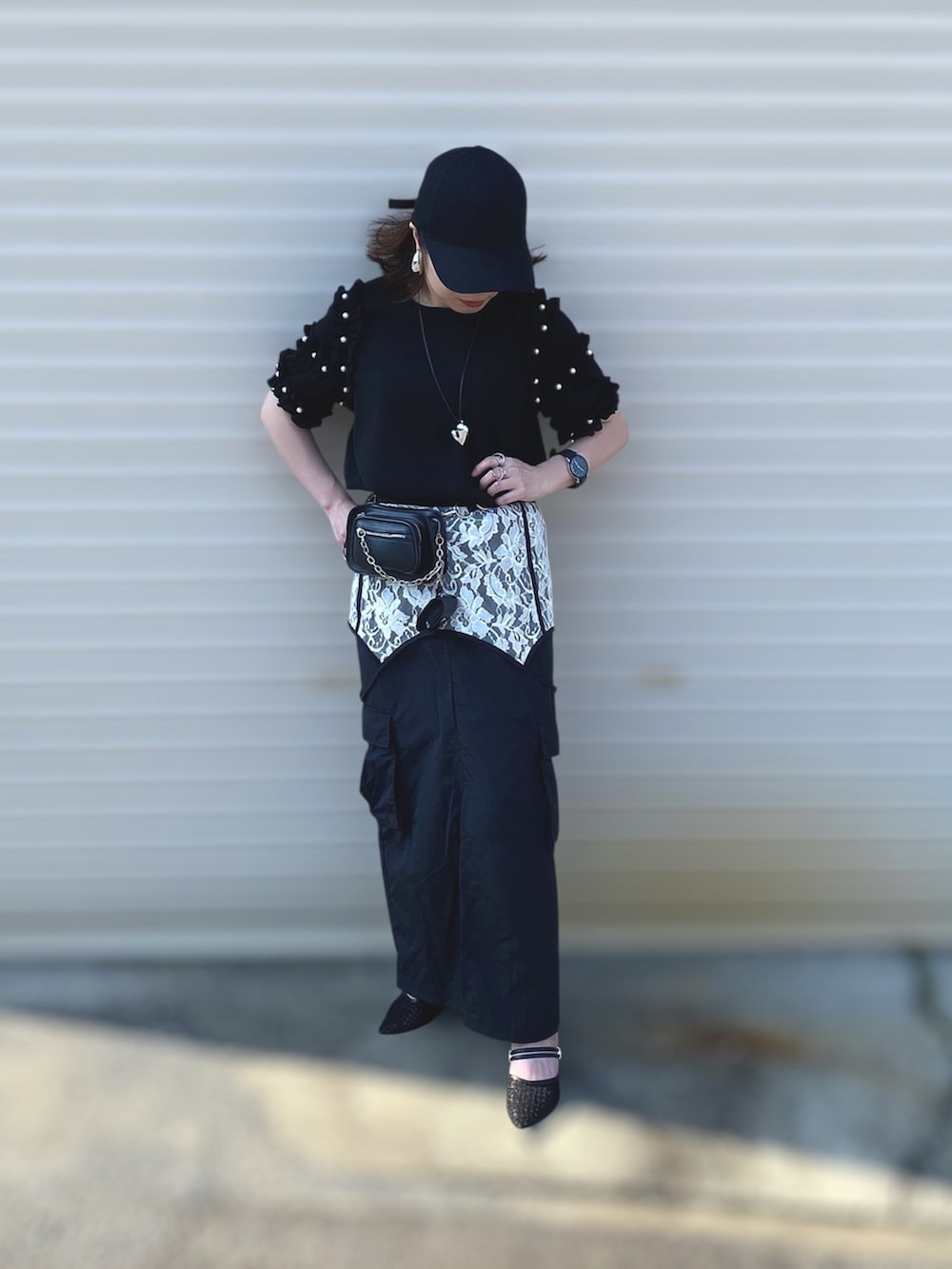 ブラック系のTシャツ/カットソー、ブラック系のスカート、ブラック系のパンプスを着用したレディースの夏コーディネートの4枚目の写真