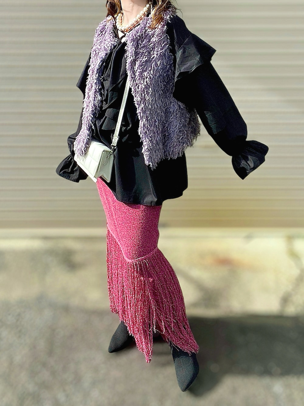 グレー系のベスト、ブラック系のシャツ/ブラウス、パープル系のスカートを着用したレディースの秋コーディネートの3枚目の写真