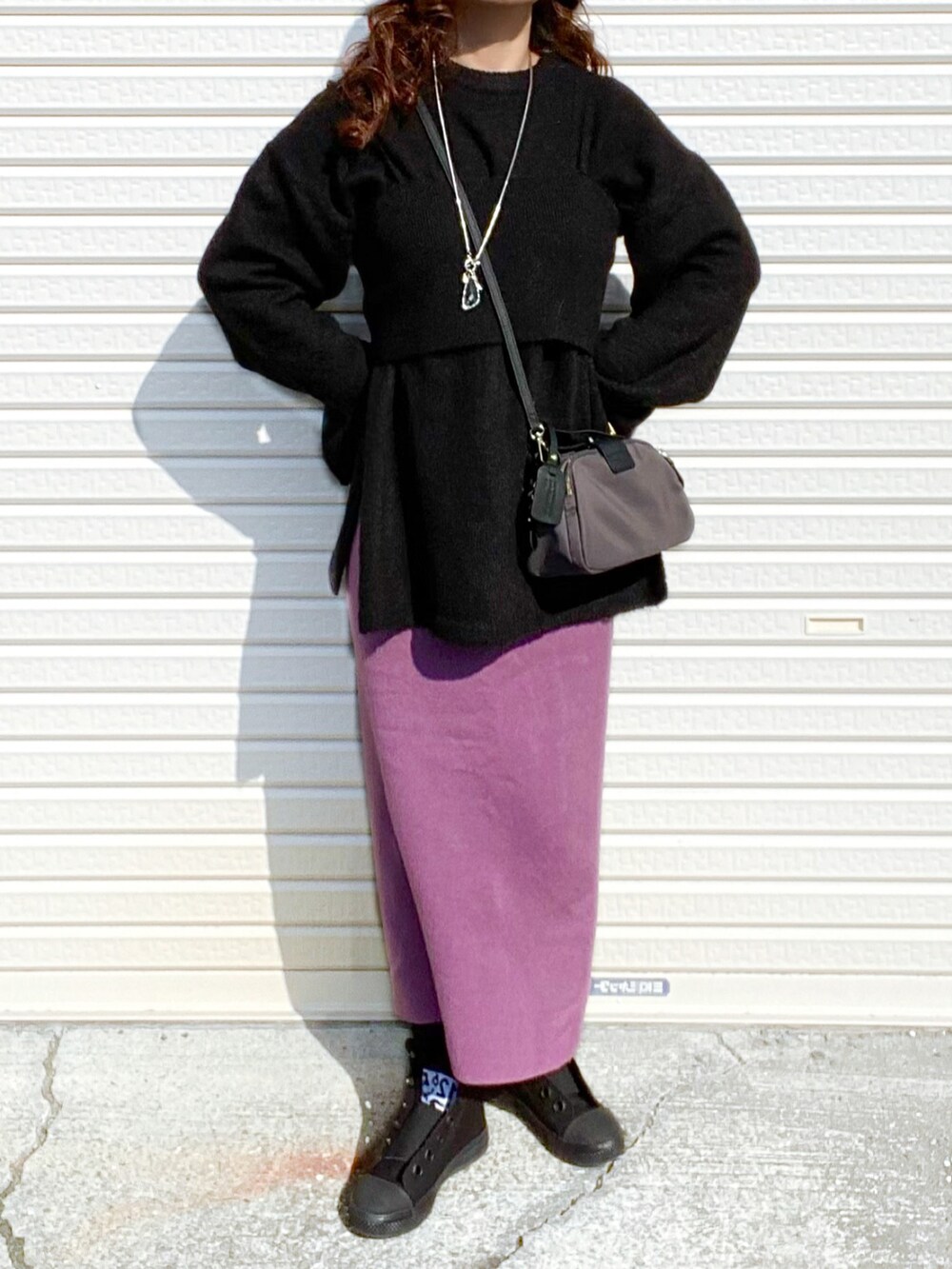 ブラック系のニット/セーター、パープル系のスカート、グレー系のショルダーバッグを着用したレディースの冬コーディネートの3枚目の写真