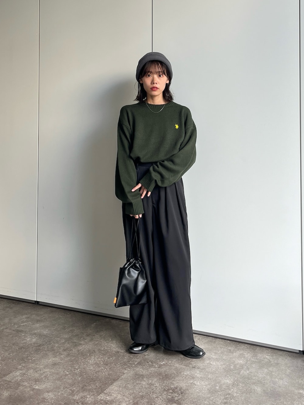 グリーン系のニット/セーター、ブラック系のその他パンツを着用したレディースの秋コーディネートの2枚目の写真